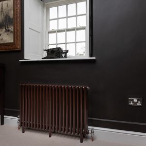 Chocolate brown multi-column radiator on a black wall