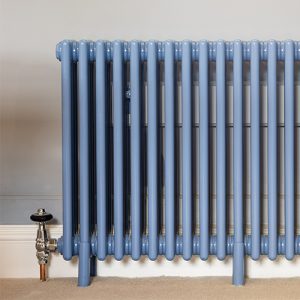 Close up of pigeon blue multi-column radiator with traditional manual valves