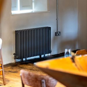 Long shot over table of anthracite multi-column radiator with traditional manual valves